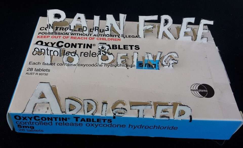 Oxycontin tablet packet with cutout message of Pain Free To Being Addicted