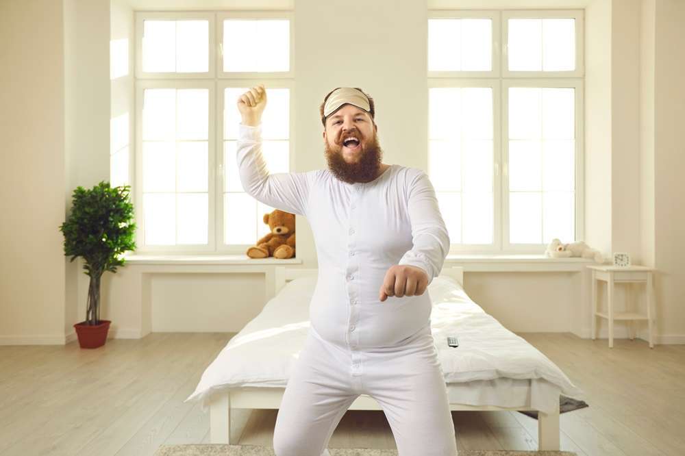 A man, dressed in white pajamas, jumped out of bed