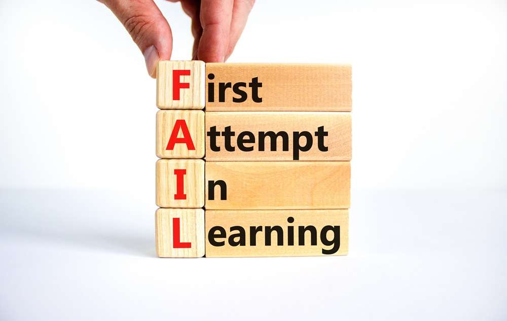 Wooden blocks with the words First Attempt In Learning spelling out the word Fail