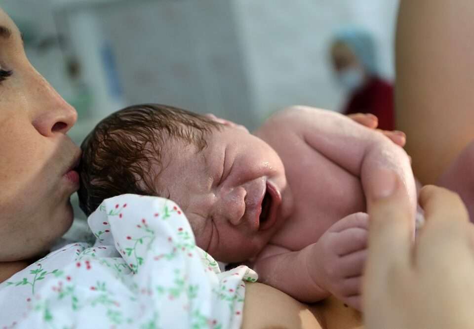 Mother with a newborn child lying on her chest