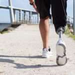 View of a man legs walking towards a jetty. One leg is a prosthetic.