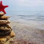 Christmas tree made from rocks by the seas shore with a star fish on top