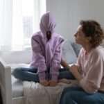 Mother and Child - Paragon PsychConnect A mother talking with a depressed introverted teen daughter in a bedroom