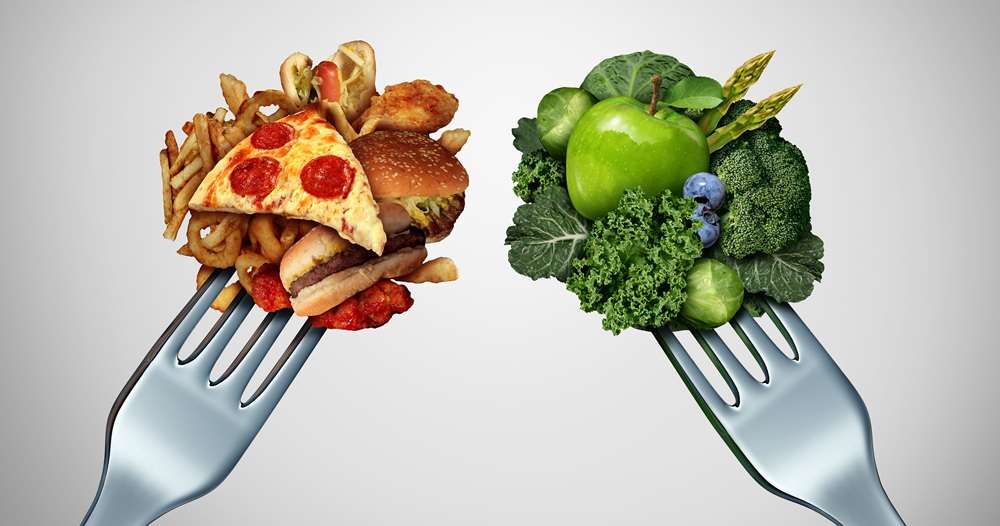 Two forks, one with carbs like chips, pizza and another fork with green vegetables