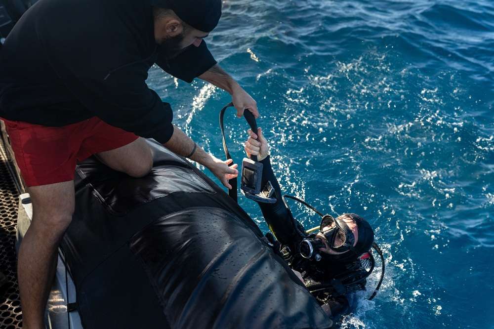 Scuba Diver - Paragon PsychConnect A scuba diver handing up their weight belt into a boat