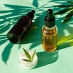 HempLeafForCosmeticPurposesMarijuanaOilAndCreamOn - Paragon PsychConnect A bottle of medical cannabis oil on a green background with cannabis leaves